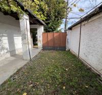 The courtyard of a family house in Jablonec with stone paving and greenery.