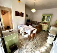 Interior of a family house with a ceramic floor, kitchen unit, and dining table.