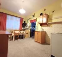 A kitchen in a family house with wooden decor, light walls, a table with chairs.