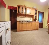 A kitchen in a family house with wooden cabinets and a classic stove.