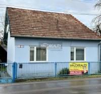 A single-story family house in Prievidza, blue facades, sloped roof, metal fence.