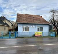 A family house in Prievidza, blue facade, sloped roof, and front fence.