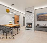 Living room in a family house with a fireplace, a table for four, and decorations.