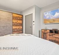 Bedroom in a family house with furniture and a wardrobe with natural wood decor.