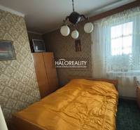 A bedroom in a 3-room apartment with retro wallpaper and a television.