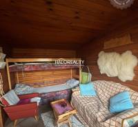 A room with a sofa, a bunk bed, and a wooden-patterned floor in the Gardens.