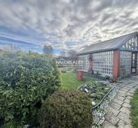 Gardens in Spišská Nová Ves with a glass house, manicured lawn, and flower bed.