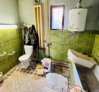 A bathroom in a family house with ceramic tiles and older equipment.