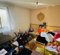 Room in a family house with clutter, surrounded by various objects and textiles.