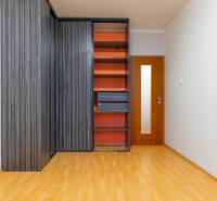 A wardrobe with integrated shelves and a floor with a wood decor in a 4-room apartment.