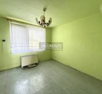 A room with a chandelier, a window, and a heating unit in a three-room apartment.