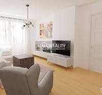 Living room with white furniture and a television in a three-room apartment.