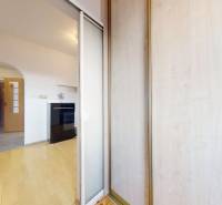 Interior of a 3-room apartment with a wooden decor floor and an entrance to the hallway.