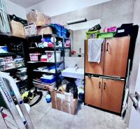 Storage space in offices with shelves, a cabinet, and numerous boxes.