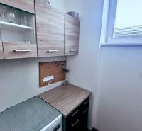 Offices with a kitchenette, cabinets with a wood finish, and a small window for lighting.