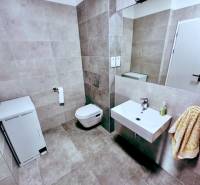 Bathroom with toilet, sink, and washing machine in offices.