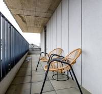A balcony with two rattan chairs in a 3-room apartment on Fialova Street.