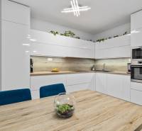 A kitchen in a 3-room apartment with white cabinets and a wood-patterned floor.