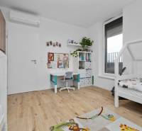 Children's room with a desk, bed, and floor with wooden decor in a 3-room apartment.