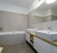 Bathroom with a bathtub, two sinks, and a mirror in a 3-room apartment.