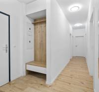 A hallway in a 3-room apartment with a wood-patterned floor and white walls.