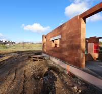 An unfinished family house on Drieňová Street in Nitra with a brick construction and building materials.