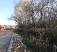 A family house construction in Nitra on Drieňová Street, surrounded by nature and trees.