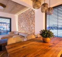Interior of a family house with a stone wall, comfortable sofa, and wooden decor flooring.