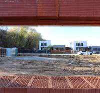 Construction of a family house on Drieňová Street in Nitra, view through the bricks to the surrounding houses.