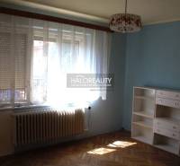 A room in a family house with a wooden decor floor, a blue wall, and a white wardrobe.