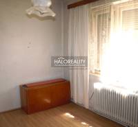 A room in a family house with a floor with a wooden decor, furniture, and a radiator.