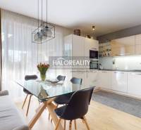 A kitchen in a family house with a dining table, a sofa, and a wooden decor floor.