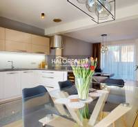 A kitchen connected to the living room, a glass table with flowers, a family house, modern lighting.