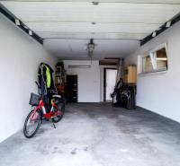 A garage in a family house with a bicycle and open doors, suitable for storage.