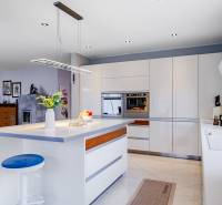 A kitchen in a family house with an island, a light fixture, a built-in oven, and accessories.