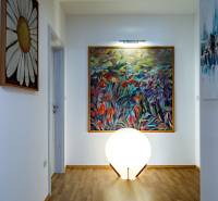Interior of a family house with artworks on the walls, floor lighting with wooden decor.