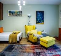 A room in a family house with an armchair, bed, carpet, and decorations. Floor with wooden decor.