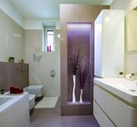 A bathroom in a family house with a bathtub, storage spaces, and decorative lighting.
