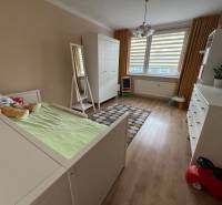 Children's room with wood decor flooring in a 4-room apartment, with white furniture.