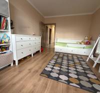 Children's room with a bed, carpet, and wooden decor flooring in a 4-room apartment.