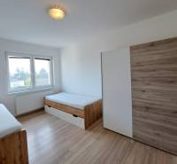 A room in a 4-room apartment with two beds and a floor with a wooden decor.