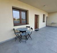 A terrace with seating in a 4-room apartment with a tiled floor and light walls.