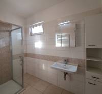 Bathroom with a shower, sink, and tiles in a 4-room apartment.