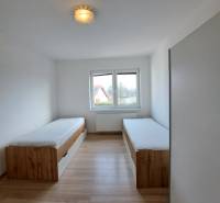 A room in a 4-room apartment with two beds and a floor with a wooden decor.