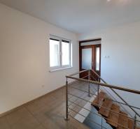 A hallway with ceramic tiles and a staircase in a 4-room apartment.
