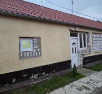 A family house on Hlavná Street in Veľká Mača with a red roof and an unfinished facade.