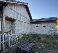 A family house in Demandice with a stack of roofing tiles and wooden structural elements.