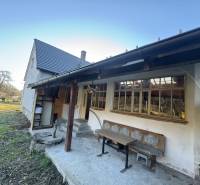 A family house in Demandice with a garden, wooden bench, and outdoor seating area.