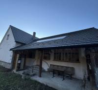A family house in Demandice with a seating area in the yard and a gentle slope.
