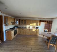 A country-style kitchen with wood-patterned flooring in a family house.